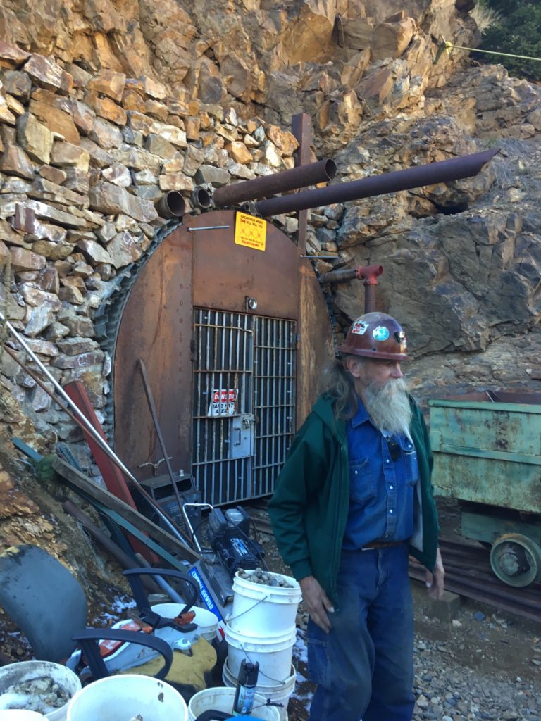 Old miner in front of mine